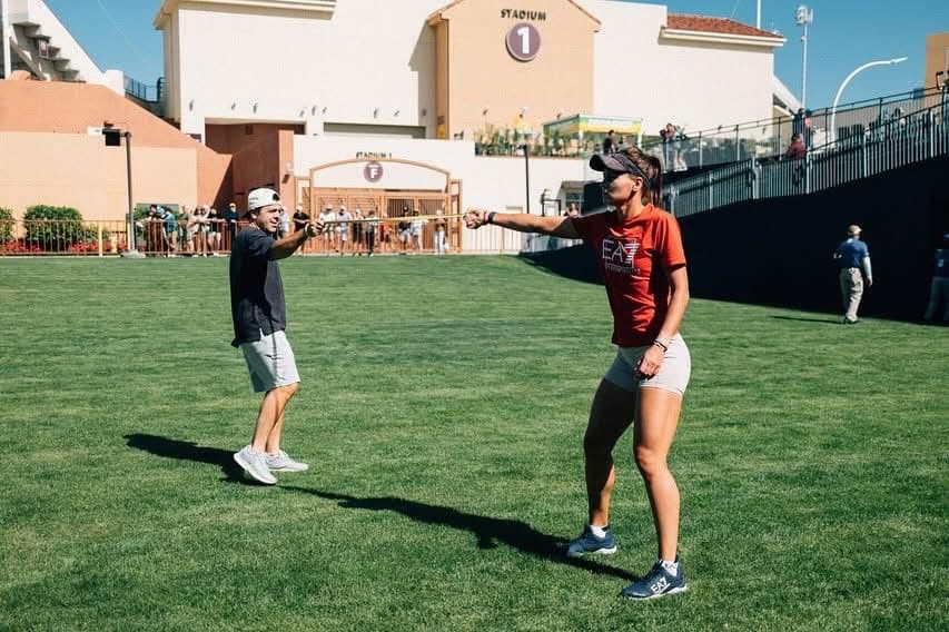 Juan Pablo Pagano guiando un ejercicio de preparación con una atleta sobre césped